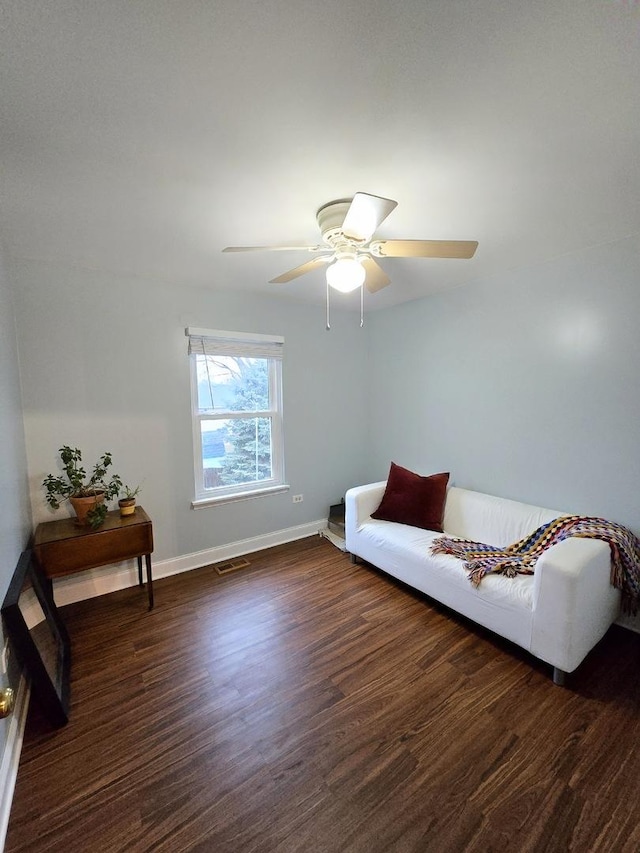 living area with dark hardwood / wood-style flooring and ceiling fan