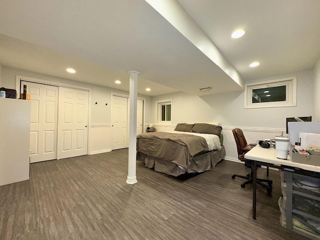 bedroom with dark hardwood / wood-style floors and multiple closets