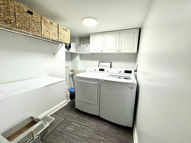 washroom with dark hardwood / wood-style floors, cabinets, and washing machine and clothes dryer