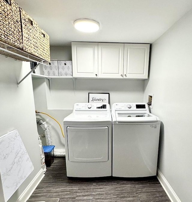 laundry area featuring cabinets, separate washer and dryer, and dark wood-type flooring