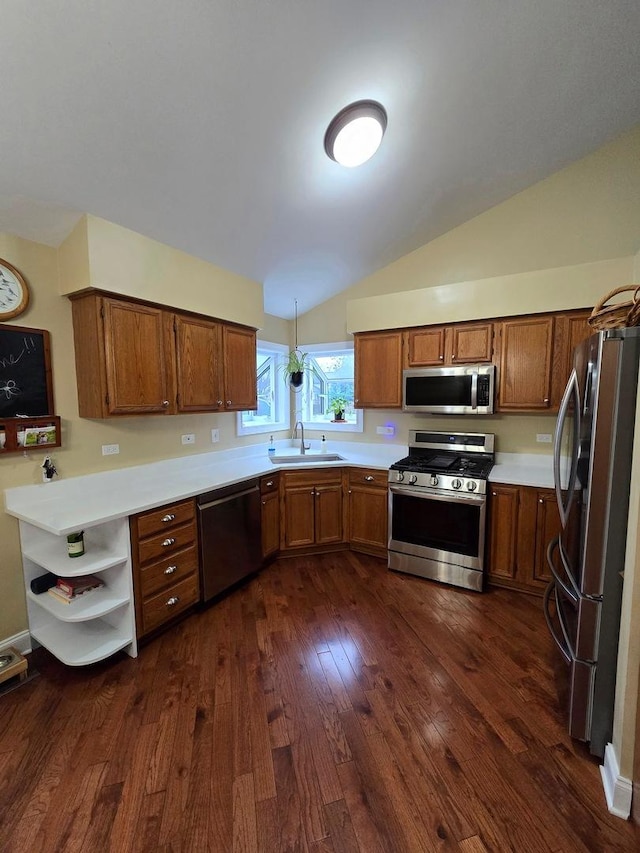 kitchen featuring dark hardwood / wood-style flooring, stainless steel appliances, vaulted ceiling, sink, and pendant lighting