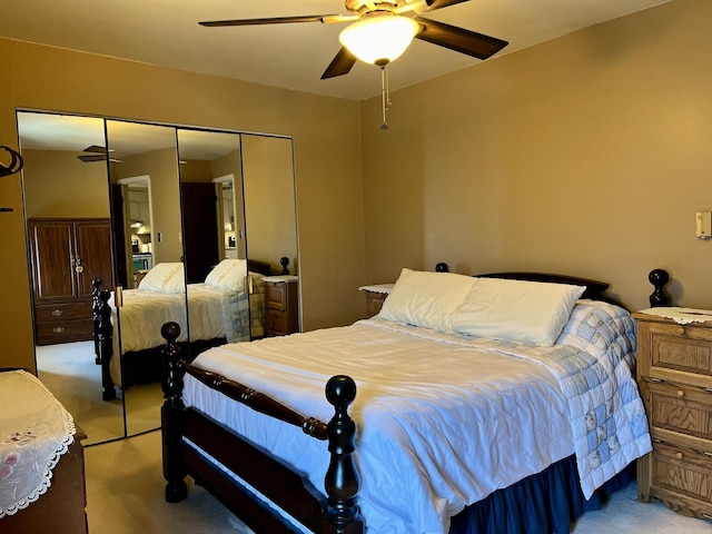 carpeted bedroom featuring ceiling fan and a closet