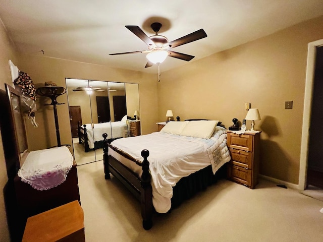 carpeted bedroom with ceiling fan and a closet