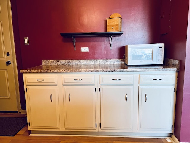 kitchen with white cabinets and light hardwood / wood-style floors