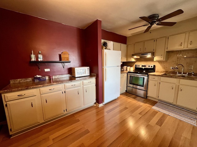 kitchen with backsplash, white appliances, ceiling fan, sink, and light hardwood / wood-style flooring