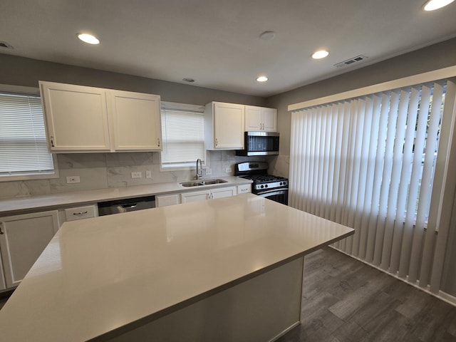 kitchen featuring sink, decorative backsplash, dark hardwood / wood-style flooring, white cabinetry, and stainless steel appliances