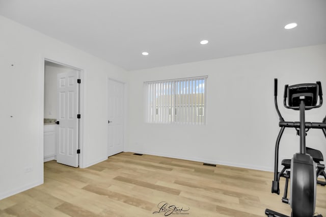 exercise room with light hardwood / wood-style floors