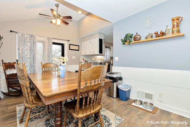 dining space featuring ceiling fan, light hardwood / wood-style flooring, and vaulted ceiling