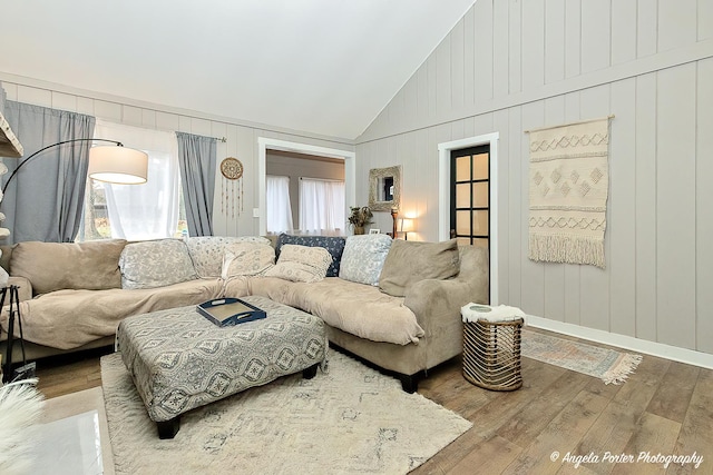 living room featuring wood walls, high vaulted ceiling, and wood-type flooring