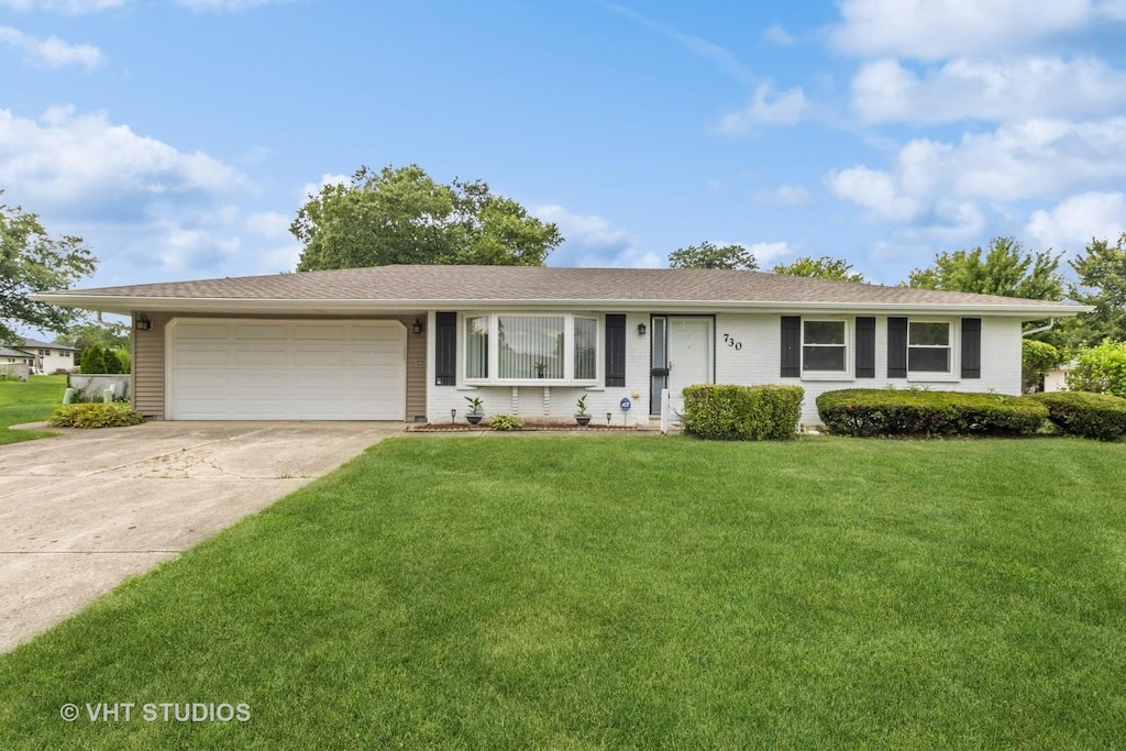 ranch-style house with a garage and a front yard