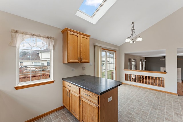 kitchen featuring lofted ceiling with skylight, hanging light fixtures, and a notable chandelier