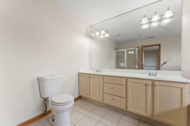 bathroom featuring tile patterned floors, vanity, a shower with shower door, and toilet