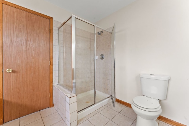 bathroom featuring tile patterned flooring, toilet, and walk in shower