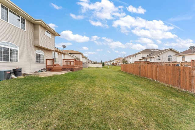 view of yard with central AC and a wooden deck