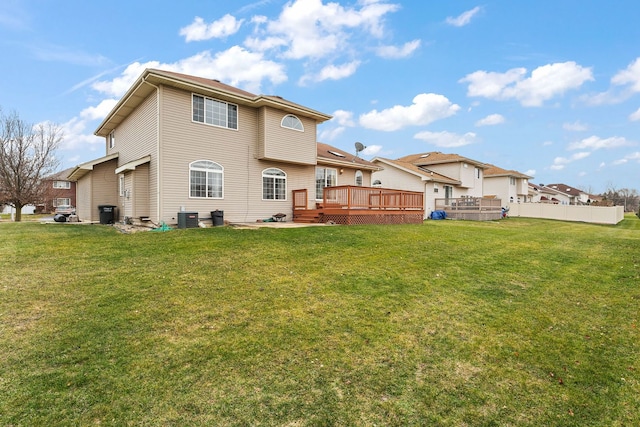 rear view of house featuring central AC unit, a yard, and a wooden deck