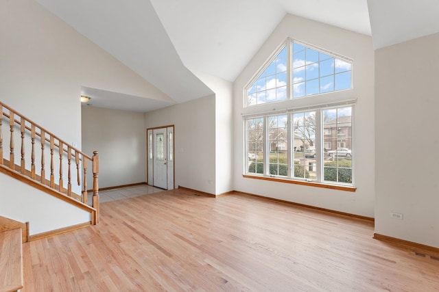 interior space with high vaulted ceiling and light hardwood / wood-style flooring