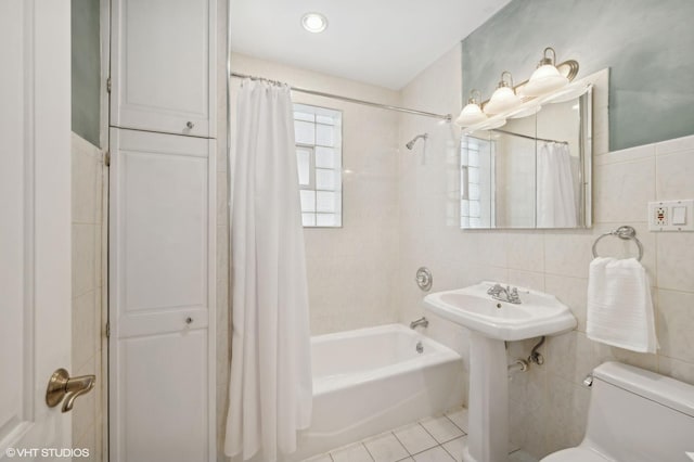 full bathroom with tile patterned flooring, tile walls, toilet, and shower / bath combo with shower curtain