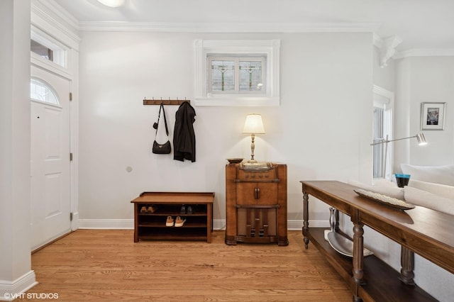 foyer featuring light wood-style flooring, baseboards, and ornamental molding