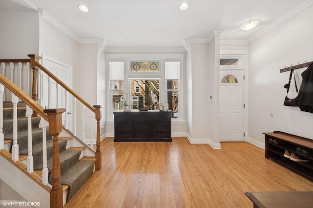 entrance foyer featuring baseboards, light wood-style flooring, stairs, and ornamental molding