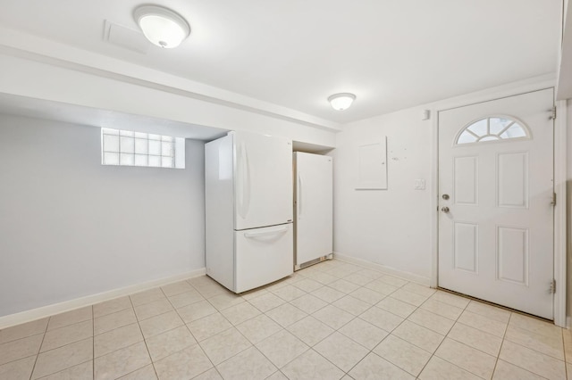 interior space featuring baseboards and light tile patterned flooring