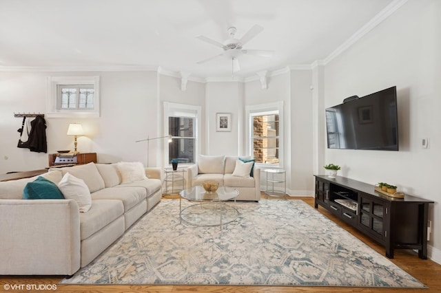 living area featuring a wealth of natural light, ornamental molding, baseboards, and wood finished floors