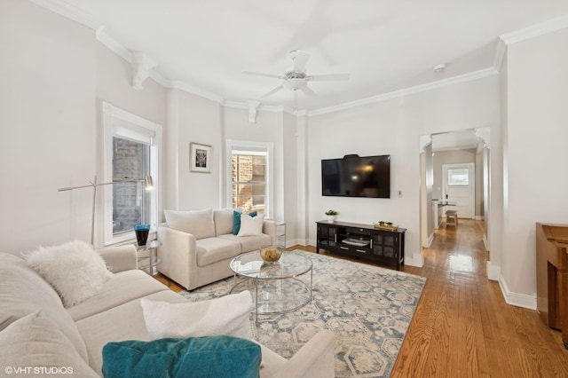 living area featuring light wood finished floors, plenty of natural light, baseboards, and ornamental molding