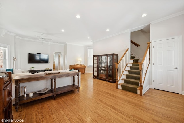 living room featuring recessed lighting, stairway, light wood-style flooring, and ornamental molding