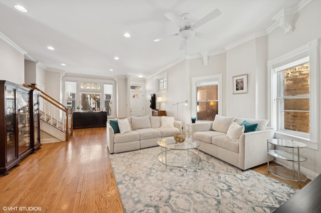 living area with baseboards, stairs, ornamental molding, recessed lighting, and wood finished floors