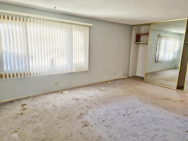 unfurnished bedroom featuring carpet flooring, a closet, and a textured ceiling