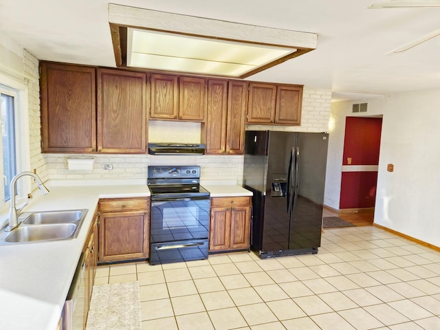 kitchen featuring black appliances, sink, decorative backsplash, light tile patterned floors, and extractor fan