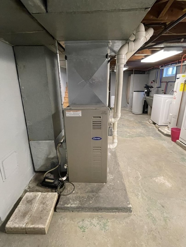 utility room with washing machine and clothes dryer and water heater