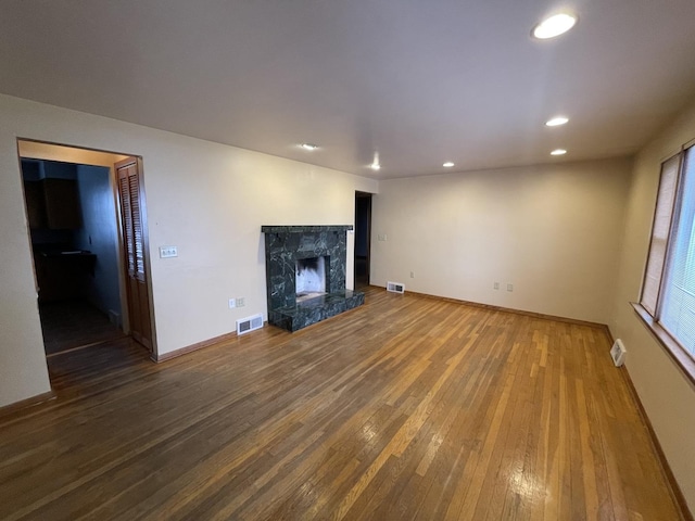 unfurnished living room featuring hardwood / wood-style flooring and a premium fireplace