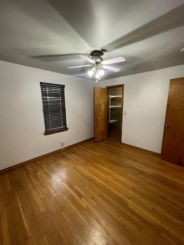 empty room with ceiling fan and hardwood / wood-style floors