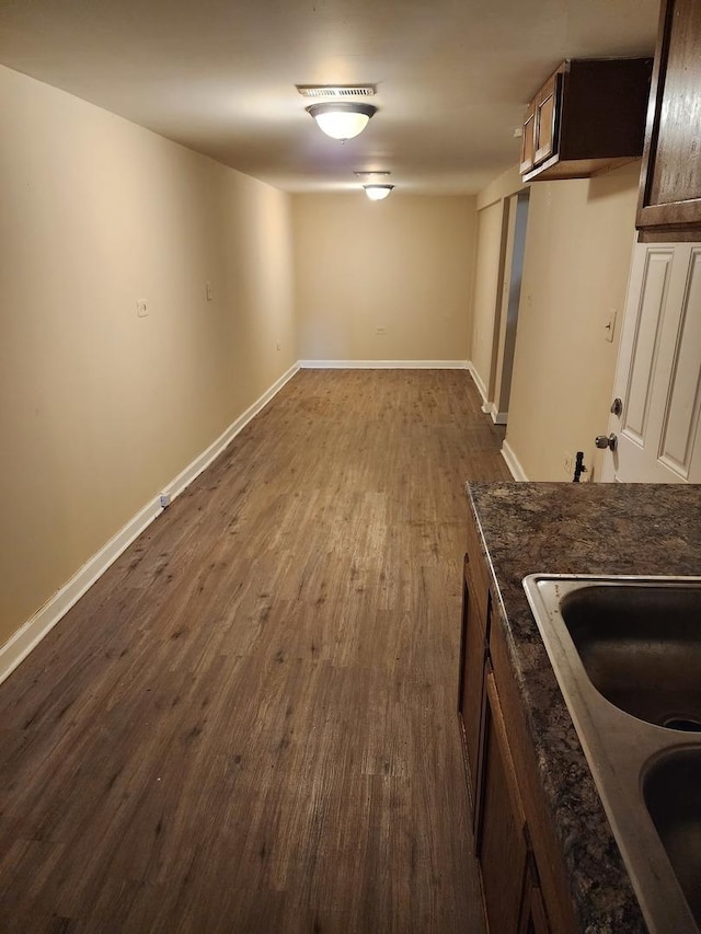 basement with dark hardwood / wood-style floors and sink