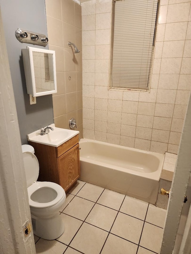 full bathroom with tile patterned floors, vanity, tiled shower / bath combo, and toilet