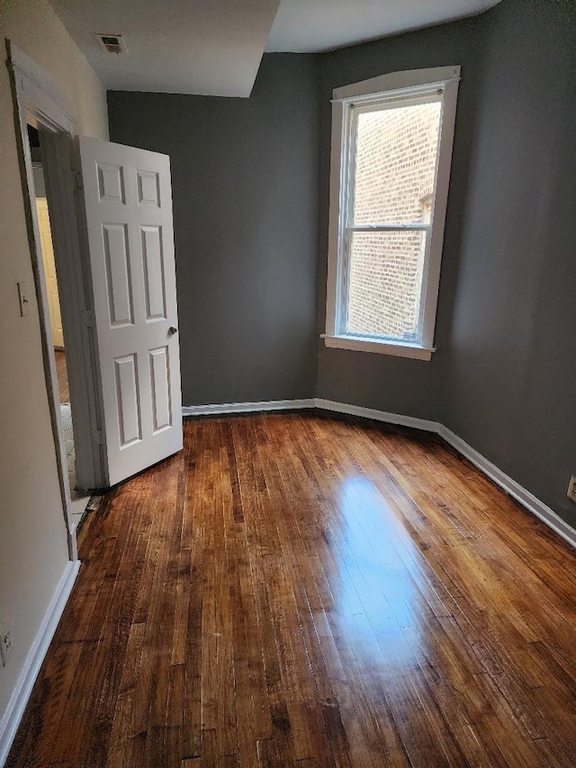 unfurnished room with dark hardwood / wood-style flooring