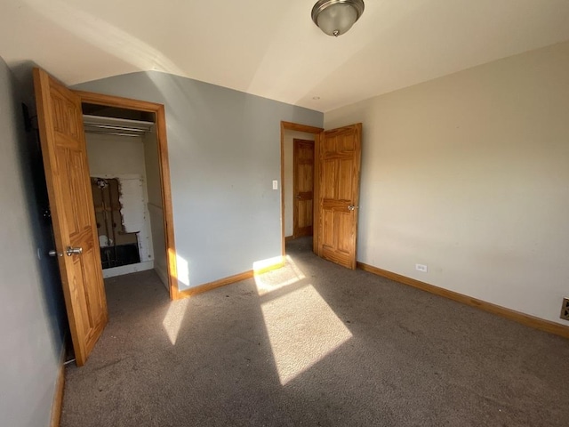 unfurnished bedroom with a closet, carpet floors, and vaulted ceiling