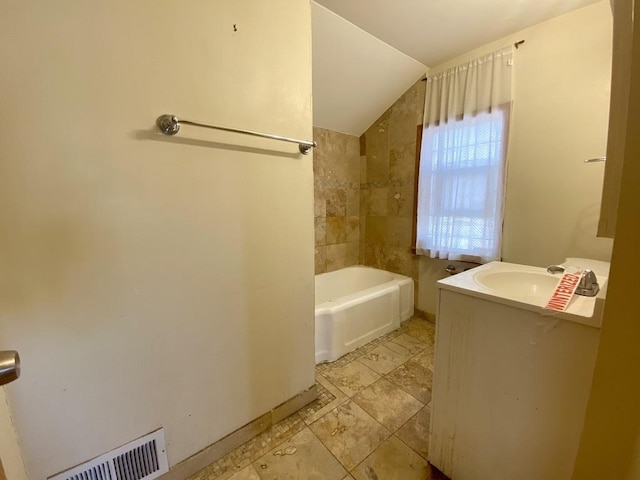 bathroom featuring vanity and lofted ceiling