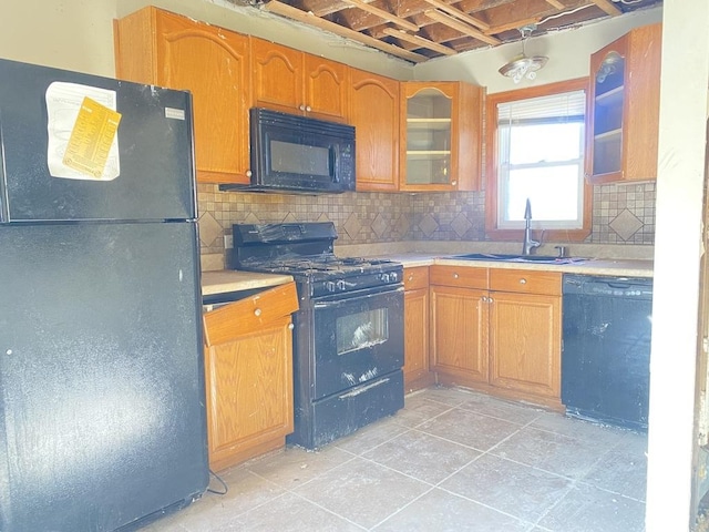 kitchen featuring light tile patterned floors, sink, backsplash, and black appliances