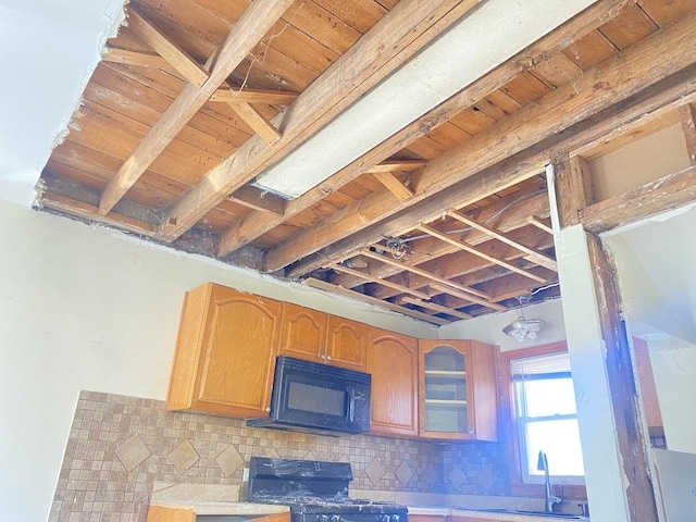 kitchen featuring sink, beamed ceiling, backsplash, black appliances, and wood ceiling