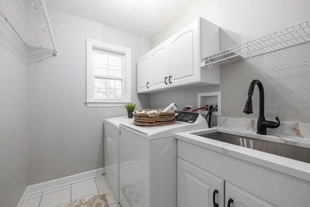 laundry room with light tile patterned flooring, cabinets, sink, and washing machine and clothes dryer