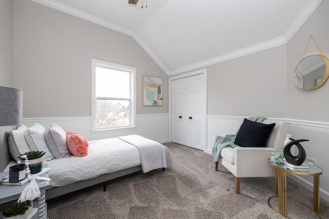 carpeted bedroom featuring ceiling fan, lofted ceiling, crown molding, and a closet