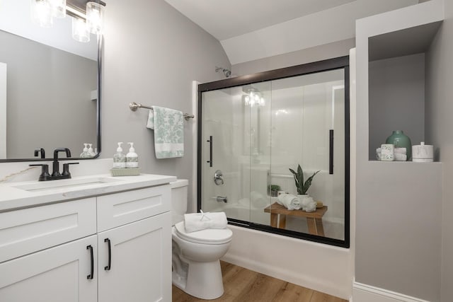 full bathroom with bath / shower combo with glass door, lofted ceiling, toilet, vanity, and hardwood / wood-style flooring