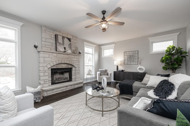 living room featuring hardwood / wood-style flooring, ceiling fan, and a fireplace