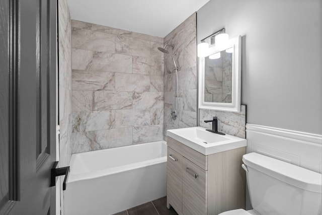 full bathroom with tile patterned floors, vanity, tile walls, toilet, and tiled shower / bath