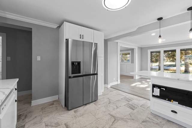 kitchen featuring light stone countertops, stainless steel fridge, white cabinetry, and ornamental molding