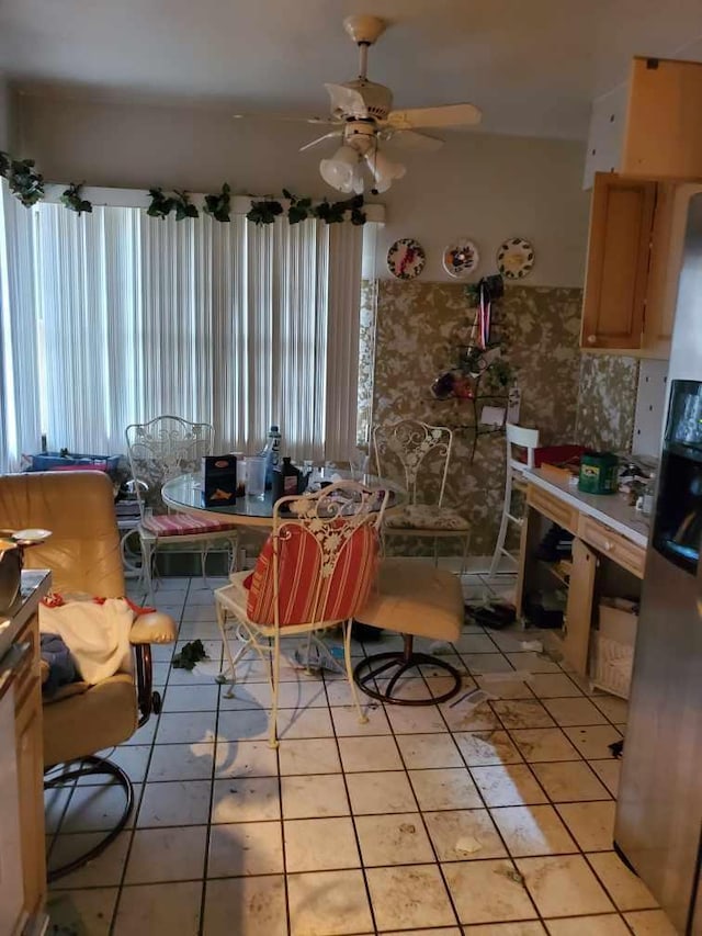 tiled dining space with plenty of natural light and ceiling fan