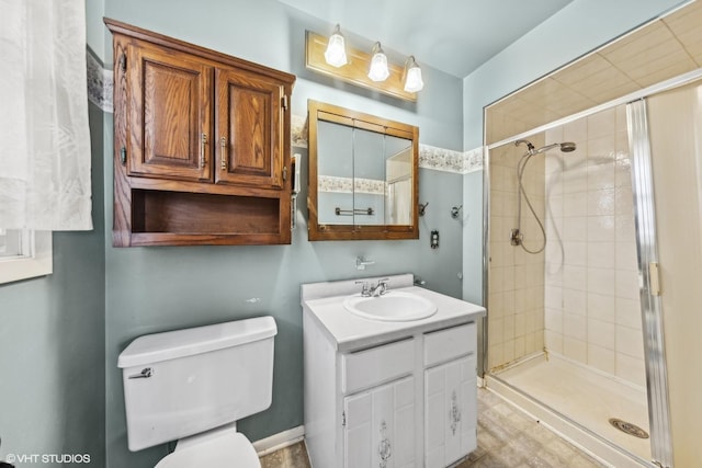 bathroom with toilet, walk in shower, and vanity