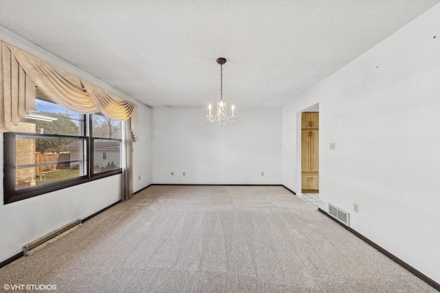 spare room with light colored carpet, a baseboard heating unit, a chandelier, and a textured ceiling