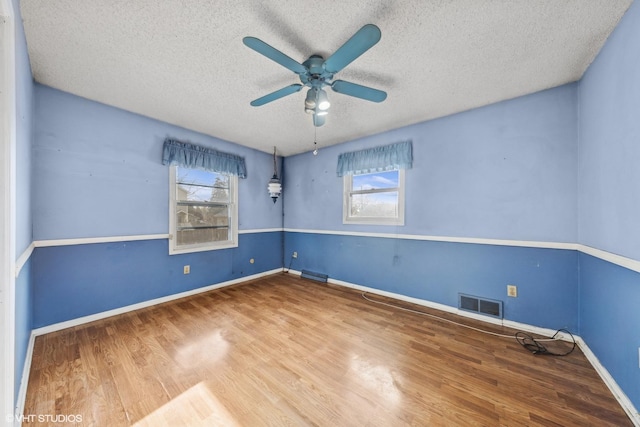 spare room featuring a textured ceiling, ceiling fan, and wood-type flooring